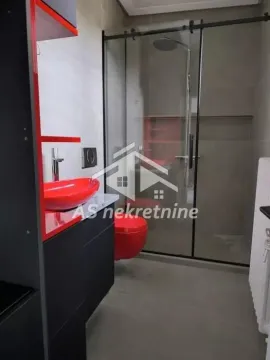 Moderno opremljeno kupatilo sa tuš kabinom i crvenim sanitarijama. - image 11