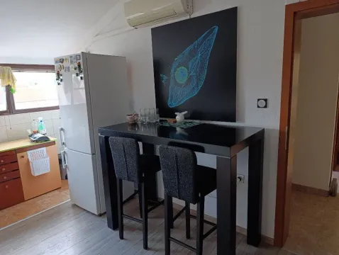 Smaller kitchen with a bar table and chairs. - image 2
