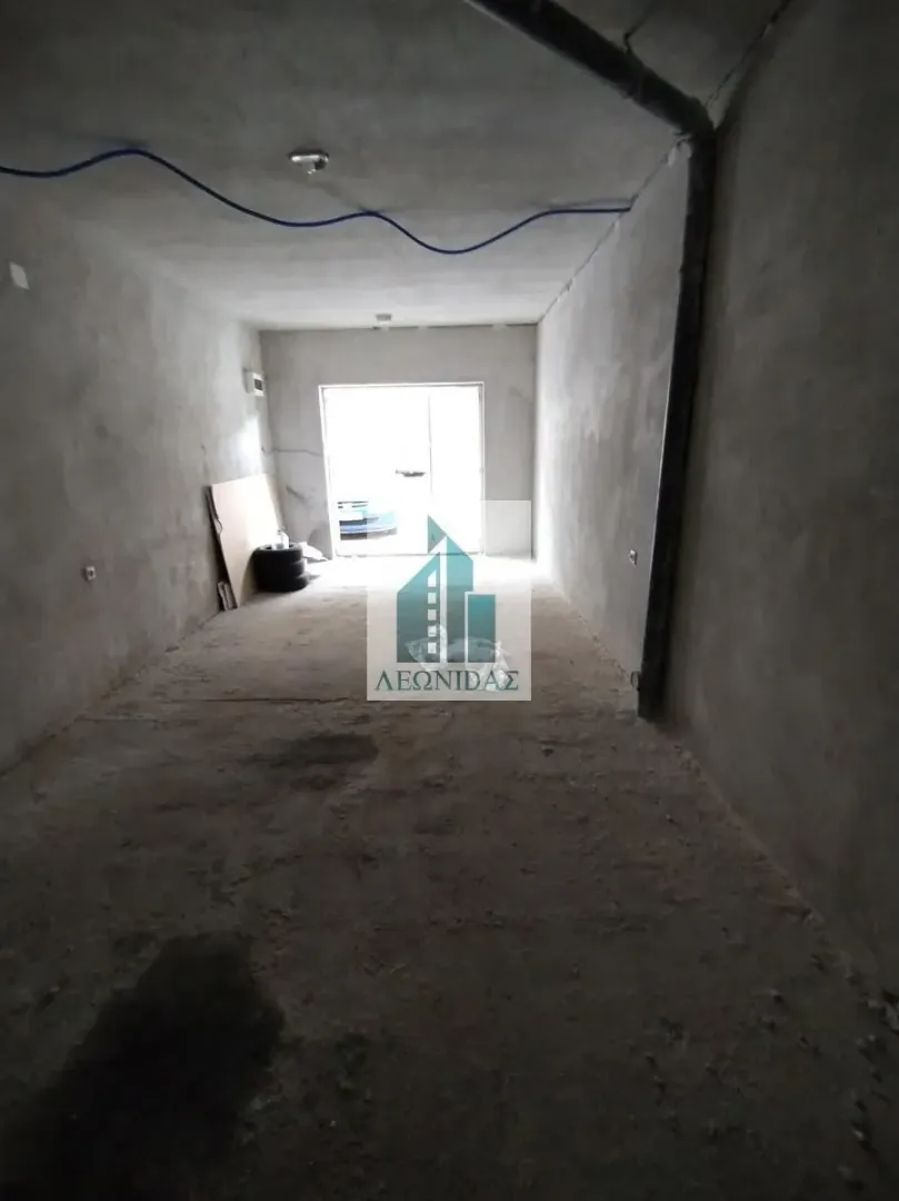 Unfinished room in grey phase with concrete floor and walls.