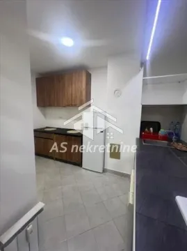 Small kitchen with wooden units and a refrigerator. - image 6