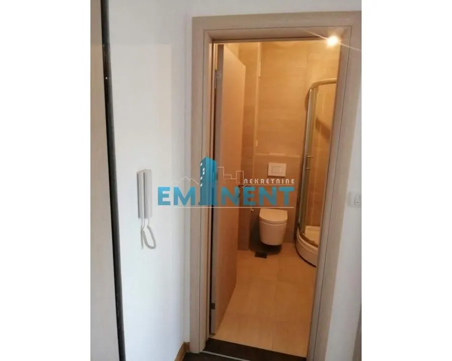 View from the hallway into the bathroom equipped with a shower cabin.