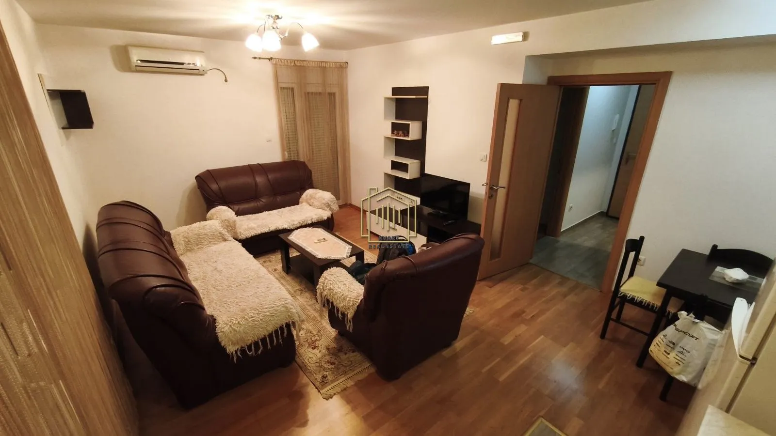 Living room with seating furniture, television, and a dining area.