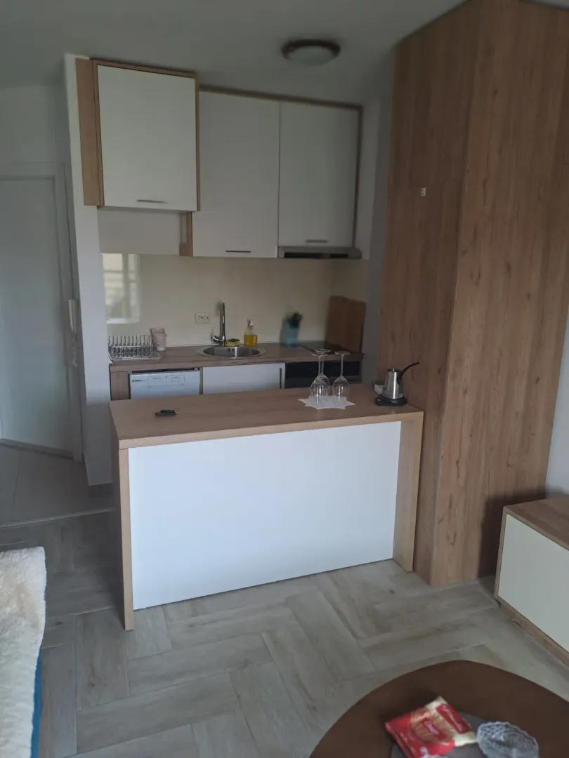 Small kitchen with white cabinets and a wooden-finish breakfast bar.