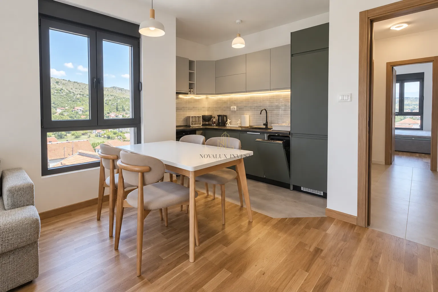 Modern kitchen with dining area and a view of nature through the window.