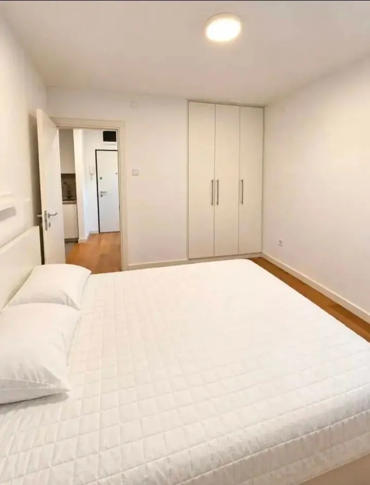 Bright bedroom with a large double bed and a fitted wardrobe.