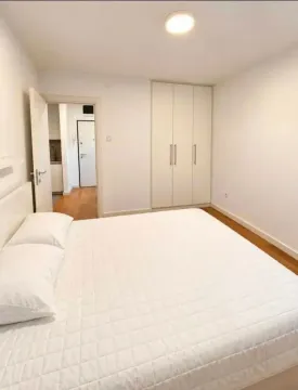 Bright bedroom with a large double bed and a fitted wardrobe. - image 6