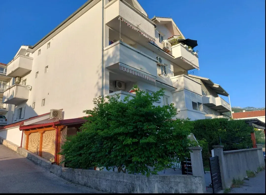 Spoljašnji izgled višespratne stambene zgrade sa terasama i dvorištem.