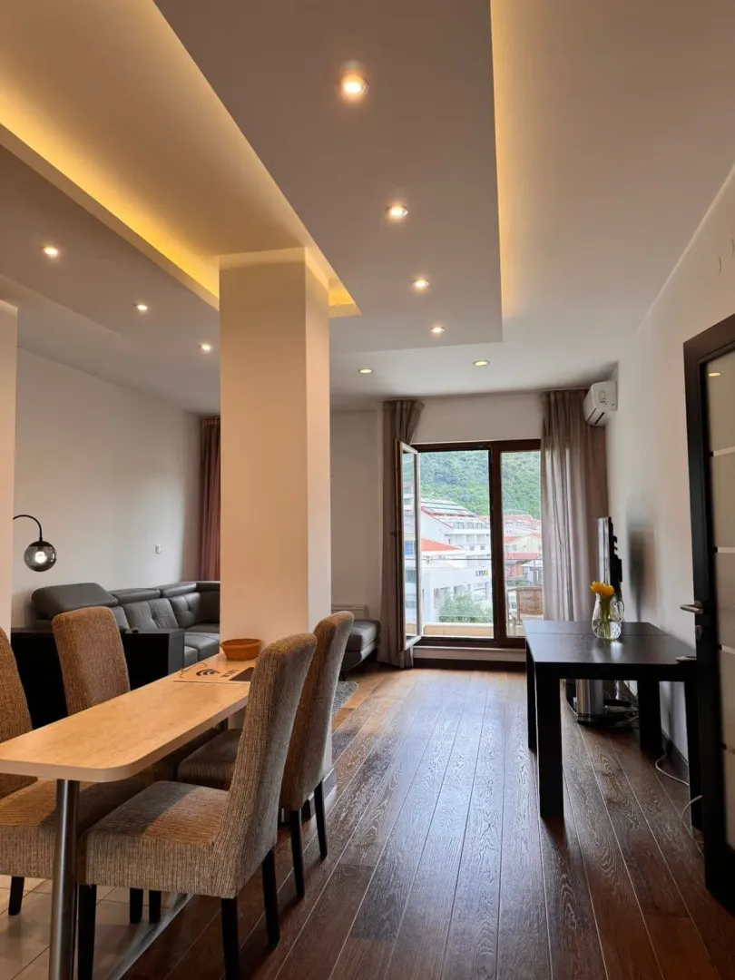 Bright and modern living room with a dining table and balcony access.