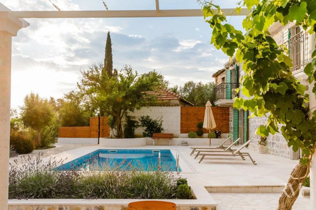 House yard with a swimming pool and sun loungers.