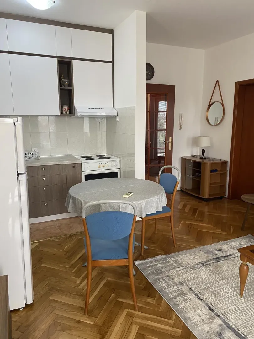 Bright kitchen with a dining table and parquet flooring.