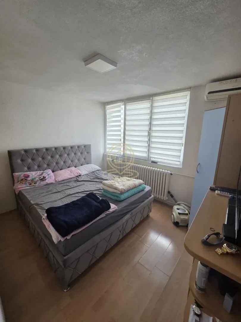 Furnished bedroom with a double bed, wardrobe, and window.