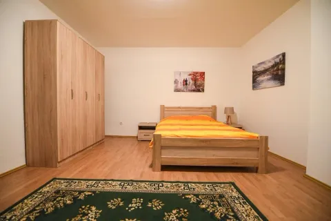 Svijetla spavaća soba sa drvenim namještajem i bračnim krevetom. - image 4