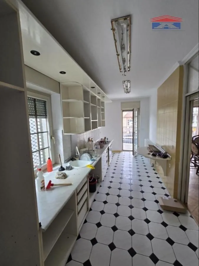 Long kitchen with a sink, cabinetry, and access to the terrace.