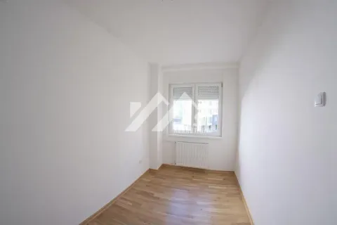 Prazna soba sa belim zidovima, parketom i jednim prozorom. - image 5