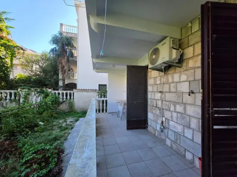 Covered terrace with a stone wall and a view of the yard. - image 6