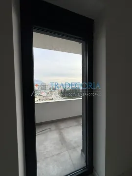 Pogled kroz balkonska vrata na terasu i okolinu grada. - image 10