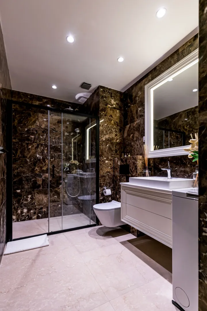 Modern bathroom with a shower cabin and marble tiles.