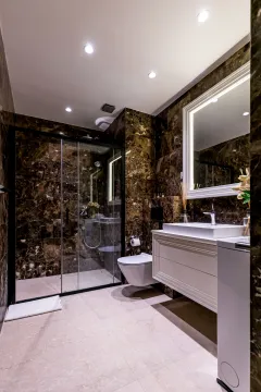 Modern bathroom with a shower cabin and marble tiles. - image 9