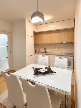 Dining area with a white table and chairs connected to the kitchen. - image 7