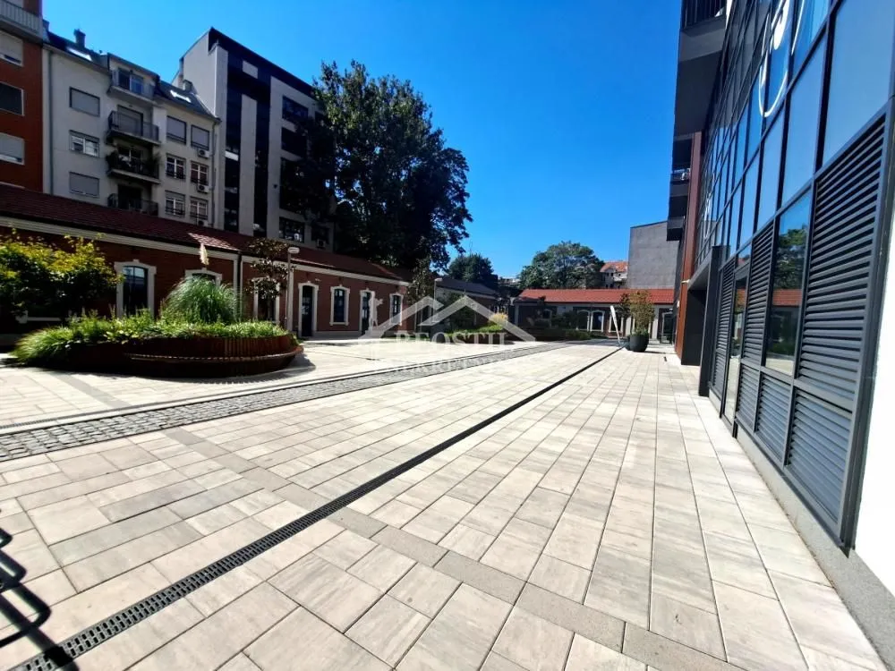 Paved courtyard in front of a modern residential and commercial building.