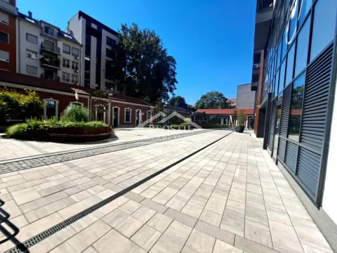 Paved courtyard in front of a modern residential and commercial building. - image 20