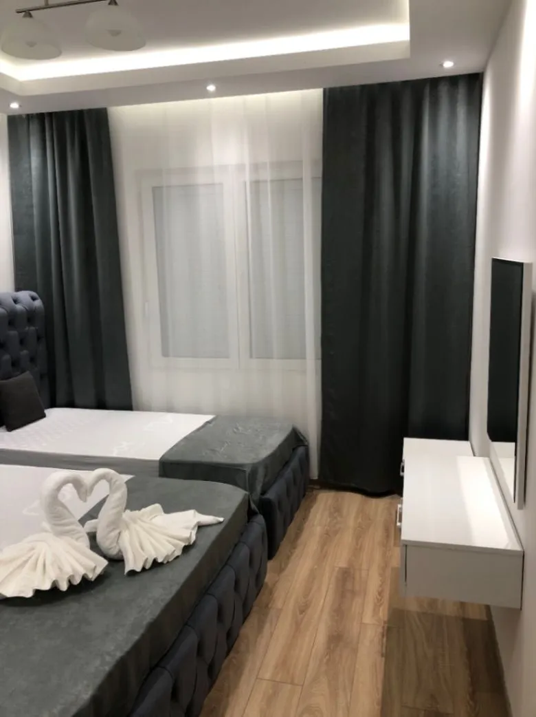 Modern bedroom with two single beds and decorative towels.