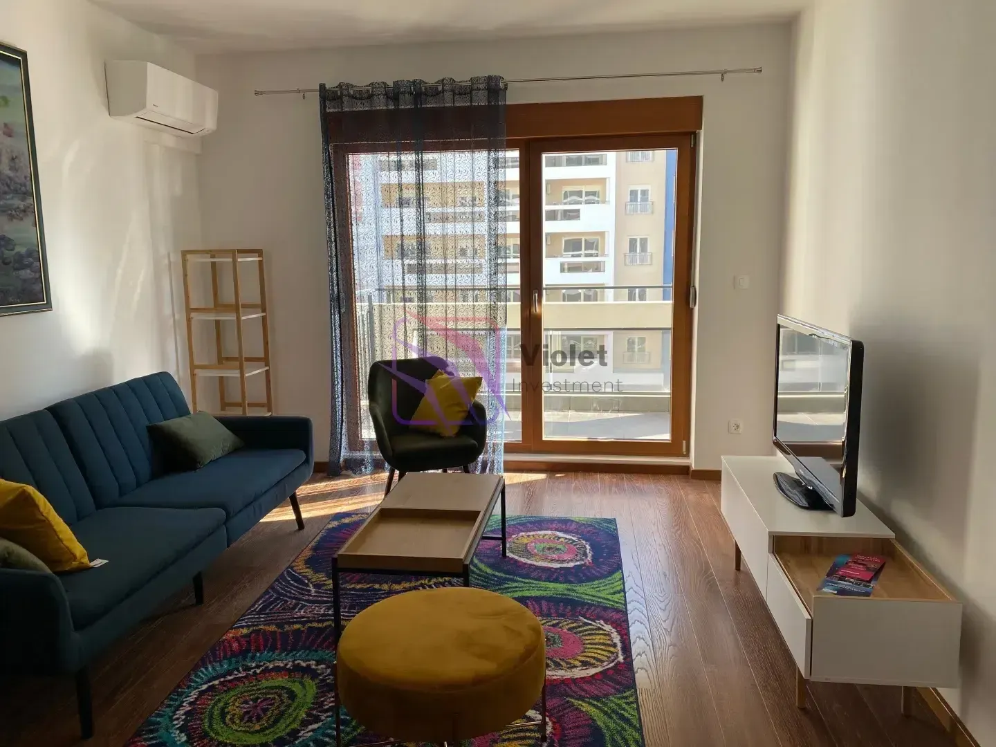 Living room with sofa, TV and access to the terrace.