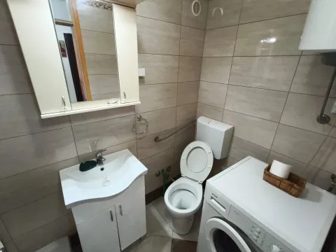 Kupatilo opremljeno umivaonikom, WC šoljom i veš mašinom. - image 7