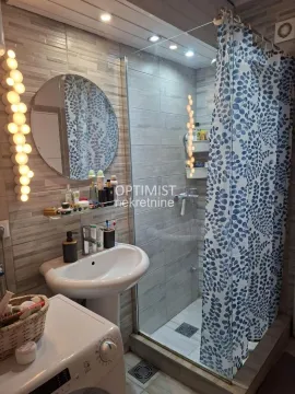 Bathroom with a sink, mirror, and shower cabin with a curtain. - image 7
