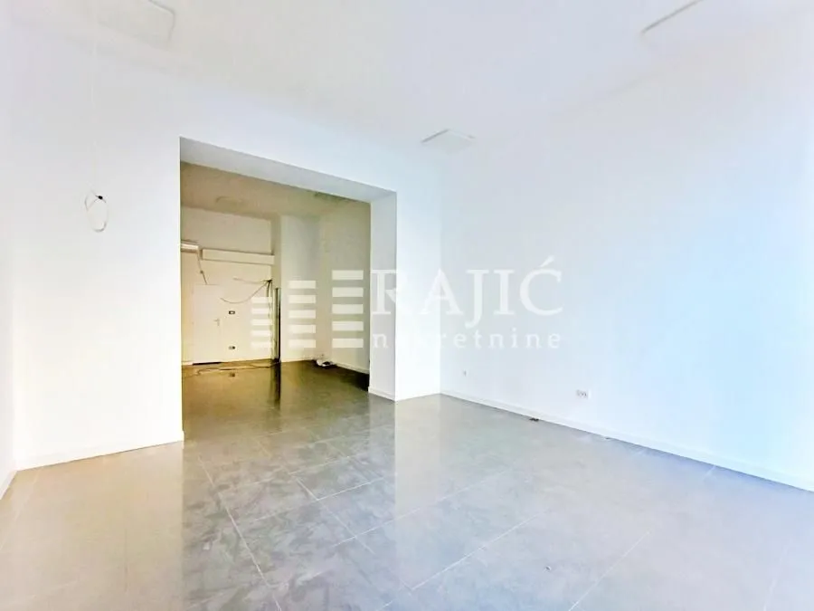 Empty bright room with white walls and tiled floors.