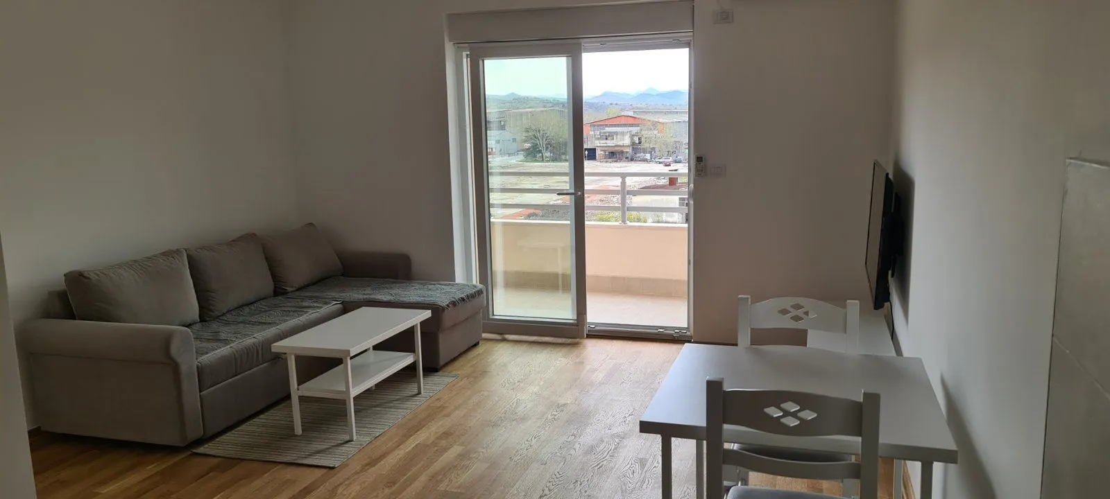 Svijetla dnevna soba sa izlazom na balkon.
