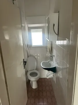 A small bathroom featuring a toilet and a sink. - image 17