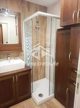 Kupatilo opremljeno tuš kabinom, umivaonikom i drvenim ormarićima. - image 14