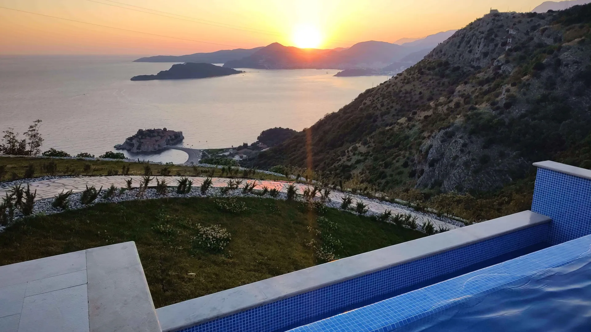 Pogled sa terase na Sveti Stefan i zalazak sunca.