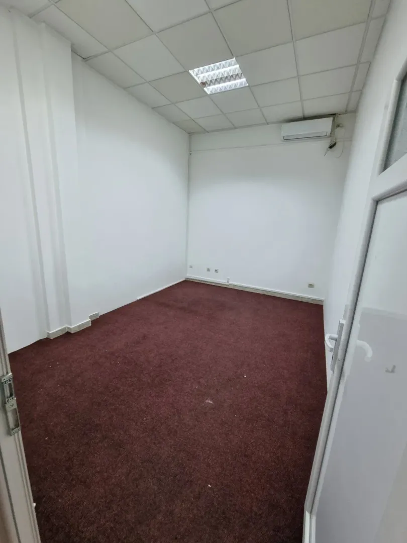 An empty room with a dark carpet.