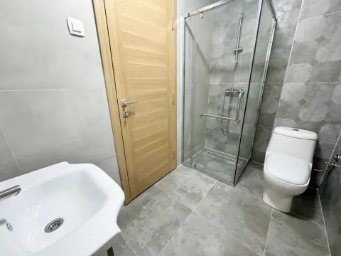 Moderno opremljeno kupatilo sa tuš kabinom, umivaonikom i WC šoljom. - image 5