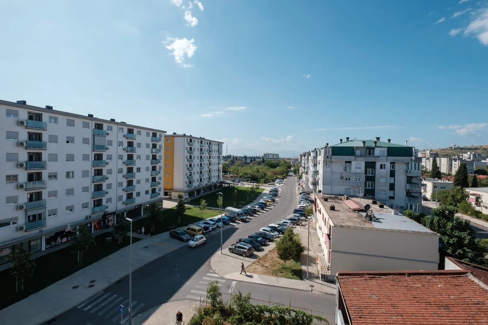Pogled sa visine na stambene zgrade i ulicu sa parkingom.