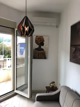 Part of the living room with a sofa, pendant light, and access to the terrace. - image 13