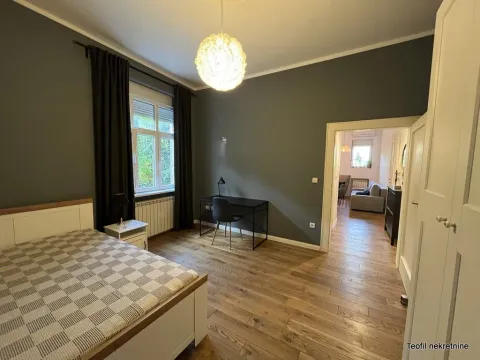 Bedroom with a bed, desk, and dark gray walls. - image 9