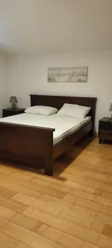 Bedroom with a double bed, bedside tables, and wooden flooring. - image 7