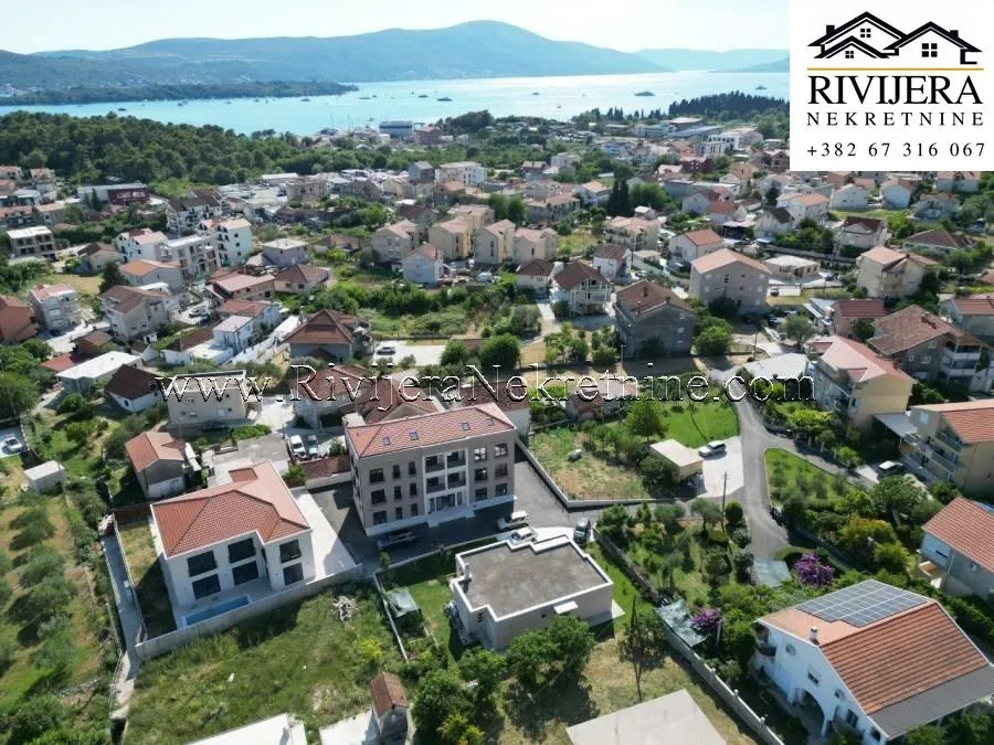 Pogled iz vazduha na stambeni objekat i okolno naselje sa pogledom na more.