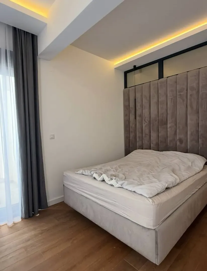 Modern bedroom with a double bed and upholstered headboard.