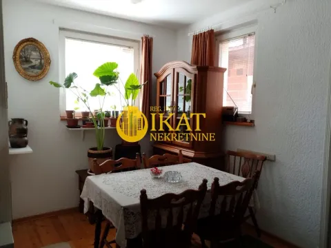 Trpezarija sa trpezarijskim stolom i drvenim ormarom. - image 2