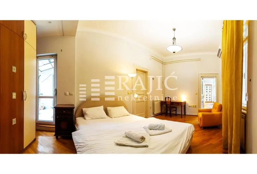 Spacious bedroom with a double bed, wardrobe, and desk.