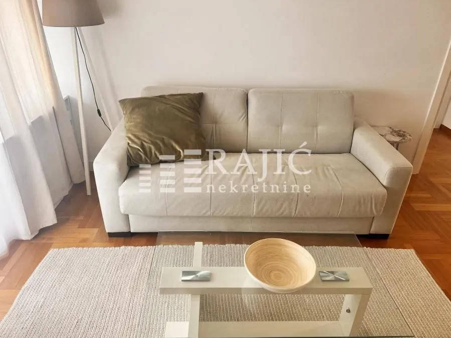 Living room with a beige sofa, coffee table and floor lamp.