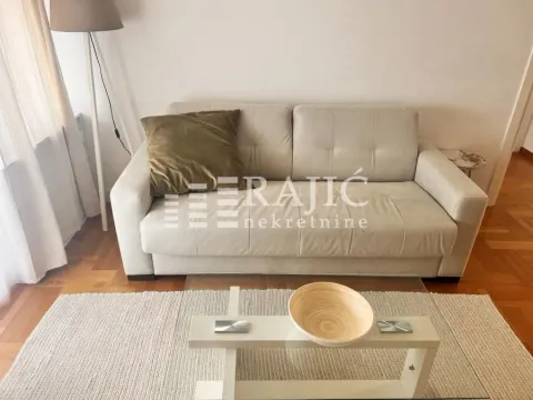 Living room with a beige sofa, coffee table and floor lamp. - image 2
