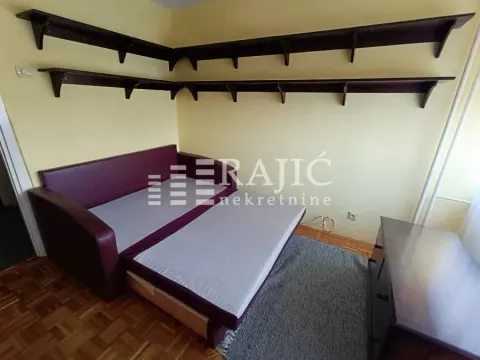 Furnished bedroom with a bed and wall shelves. - image 7