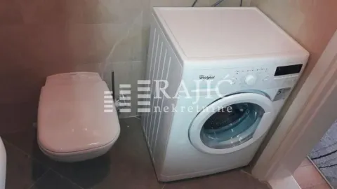 Small bathroom with a toilet and a washing machine. - image 11