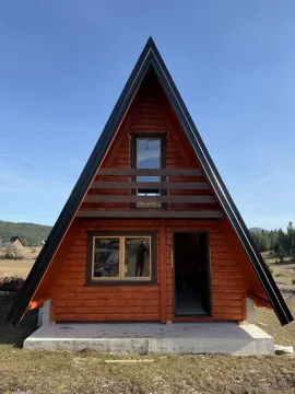 Eksterijer drvene A-frame vikendice sa balkonom i ulaznim vratima. - image 5