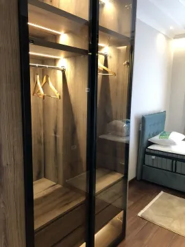 Modern bedroom featuring an illuminated built-in wardrobe next to the bed. - image 24